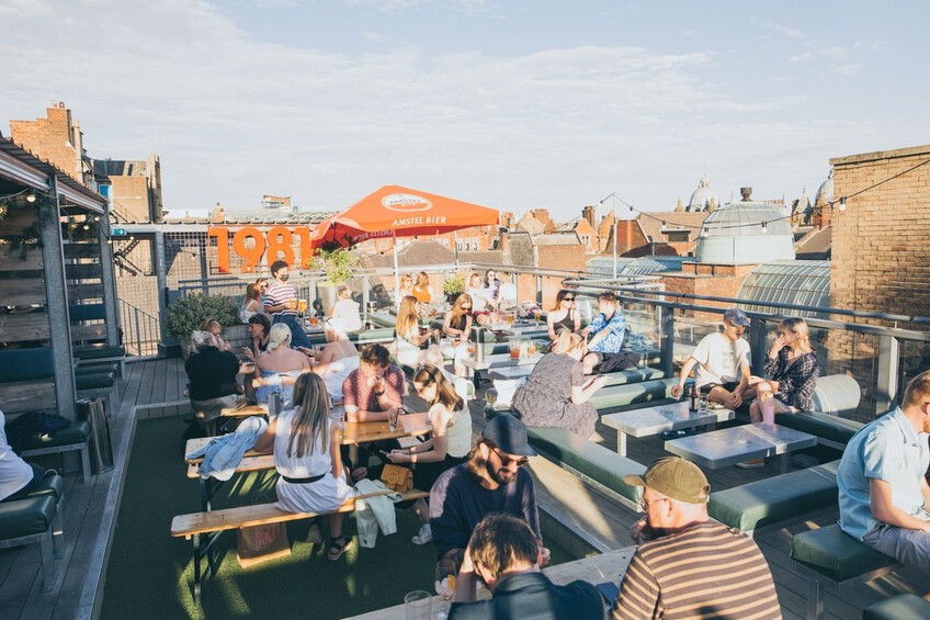 People enjoying the evening sun on the roof of Headrow House. Recommended by Treasure Hunt Leeds.